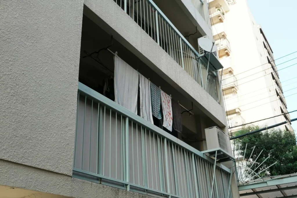 실외기와 세탁물이 거치된 실제 아파트 발코니의 외관 사진으로, 하중 집중 현상과 구조적 안전성을 분석하기 위한 실제 주거 환경 사례